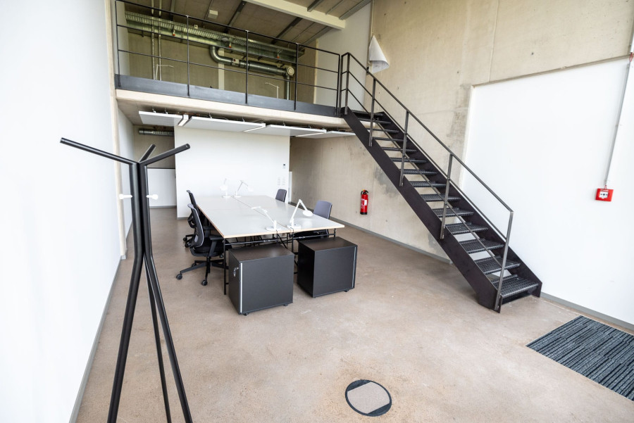 Loft B&uuml;ro mit einer Trennwand und Treppenaufgang zur oberene Ebene