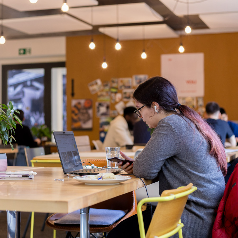Bistro, wo mehrere Personen am Laptop arbeiten oder essen