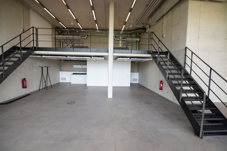 Modernes, industrielles Loft B&uuml;ro mit hohen Decken und Treppenaufg&auml;ngen zur zweiten Ebene