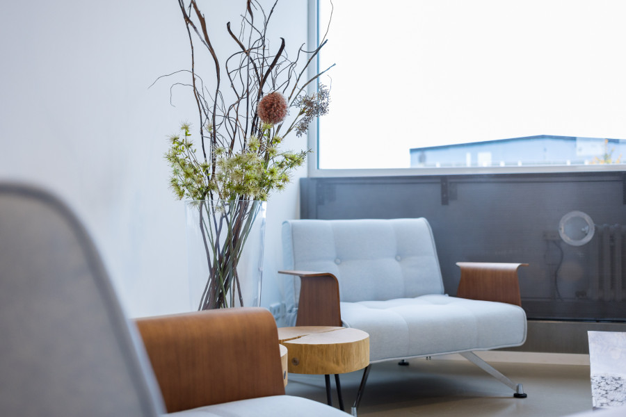 Sitzm&ouml;glichkeiten im 4. OG des Factory Campus, hellblaue Sessel mit kleinem Holztisch und Trockenblumen-Deko