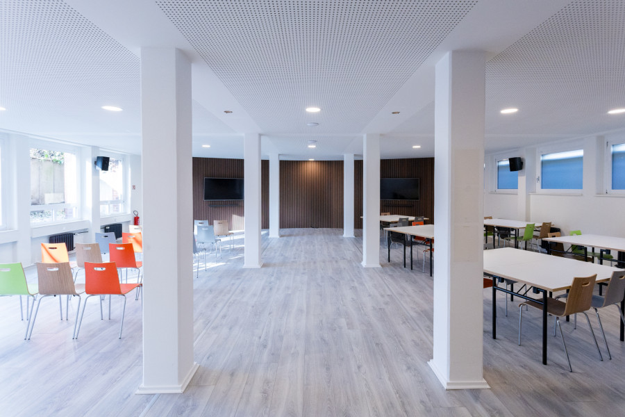 Meetup-Projektraum mit gro&szlig;en Bildschirmen an abgerundeten W&auml;nden mit braunen Paneelen