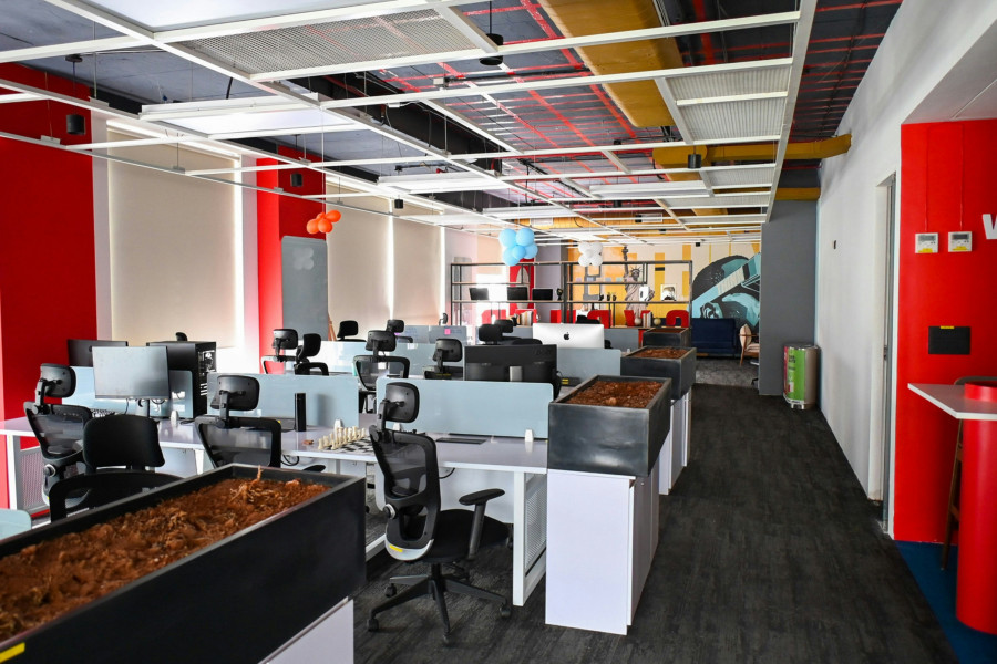 Coworking Space mit roten Details und vielen Schreibtischen